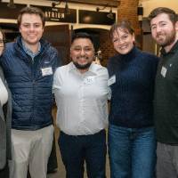 Group of 5 event attendees standing together and smiling for photo